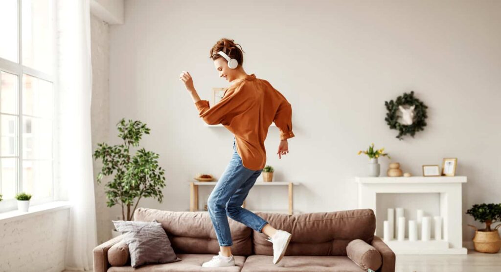femme qui danse sur son canapé avec son casqueapprendre à danser quand on a pas le rythme