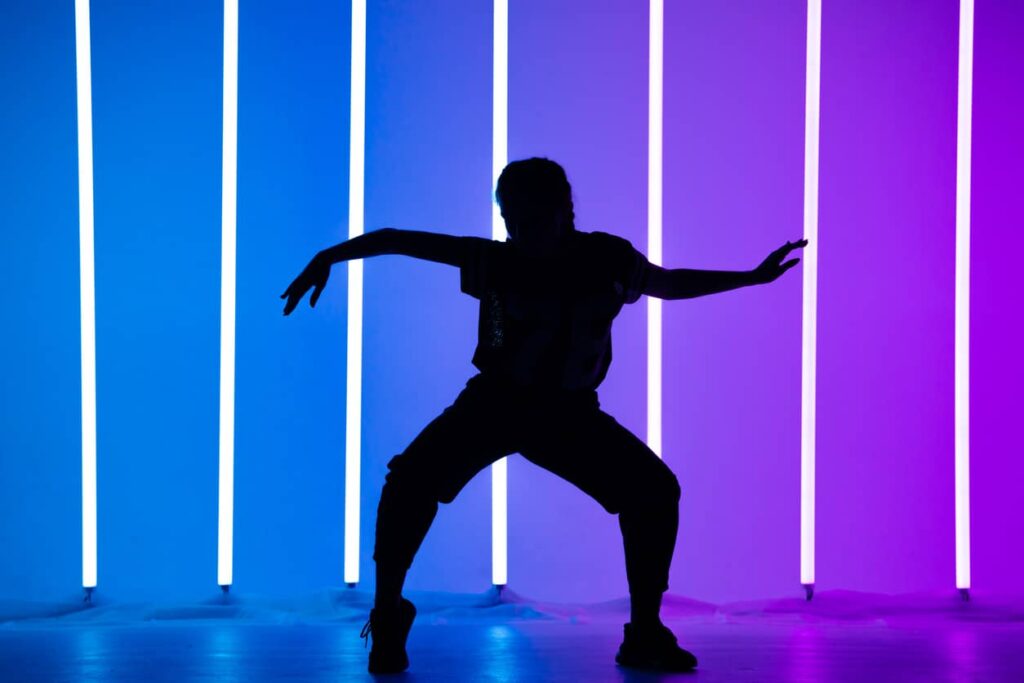 apprendre à danser seul danseur devant des néons violets