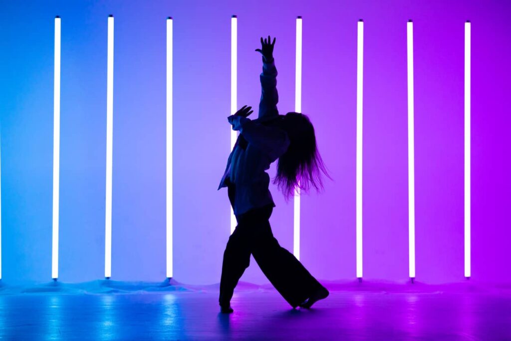 apprendre à danser seul - danseuse devant des néons violets