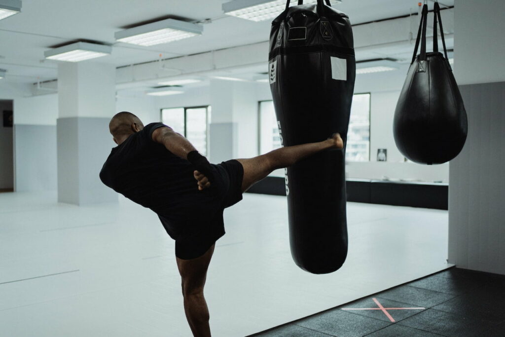 boxe cardio :  un homme donnant un coup de pied dans un sac de frappe