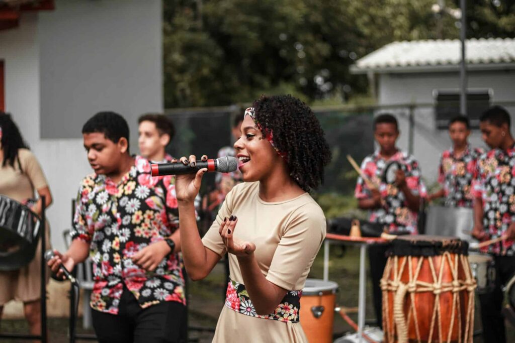 Une femme chante et des personnes dansent une danse haitienne
